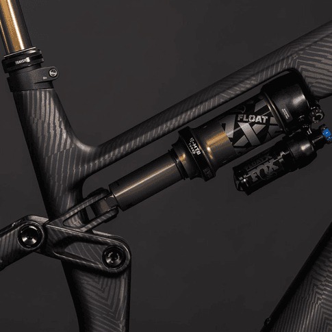 Seitenansicht des Fox Float X Dämpfers, der in den mattschwarzen Carbon-Hinterbau eines E-MTBs integriert ist.