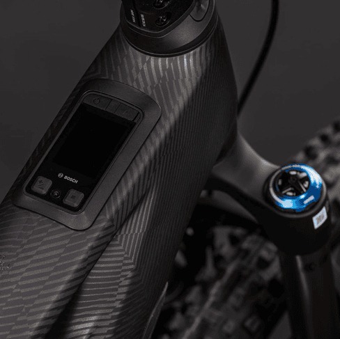 Nahaufnahme des Oberrohrs eines E-Mountainbikes aus Carbon mit integriertem Bosch-Display und Steuerungsknöpfen.